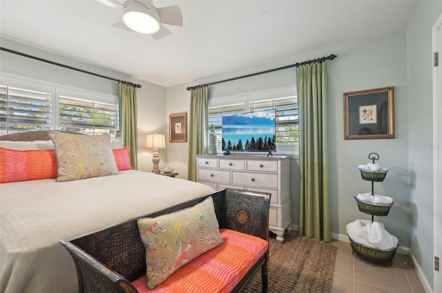 tiled bedroom with multiple windows and ceiling fan