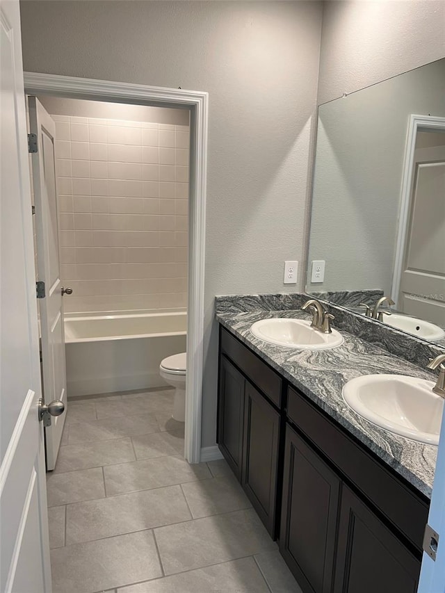 full bathroom with toilet, tile patterned flooring, tiled shower / bath combo, and vanity