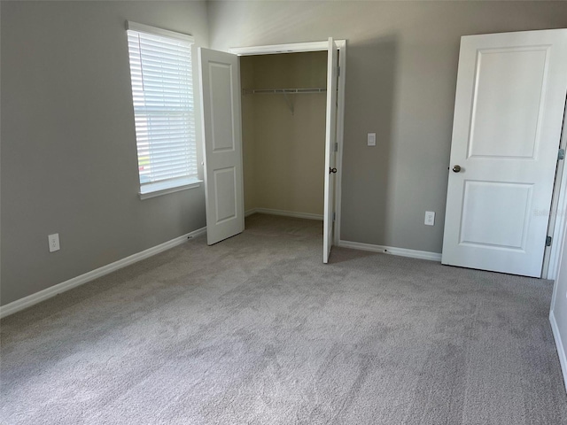 unfurnished bedroom featuring light colored carpet and a closet