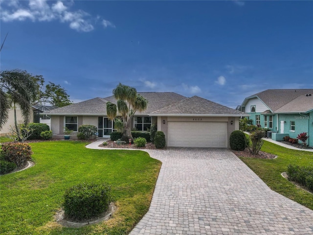 single story home featuring a garage and a front lawn