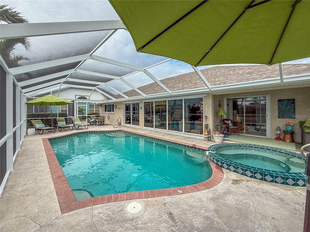 view of swimming pool featuring an in ground hot tub, a lanai, and a patio area