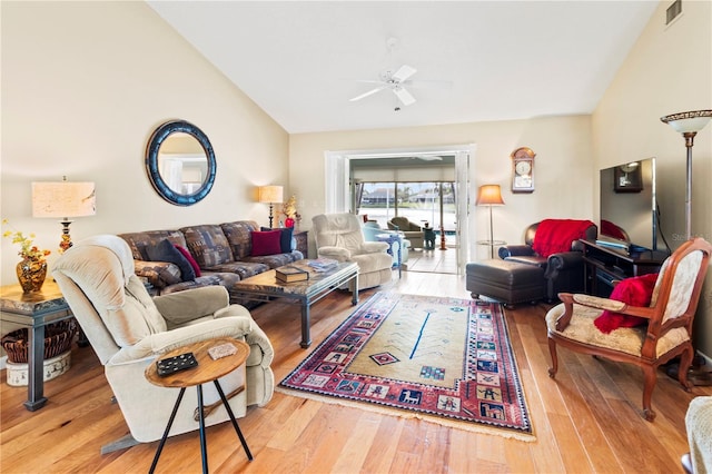 living room with hardwood / wood-style flooring, ceiling fan, and vaulted ceiling