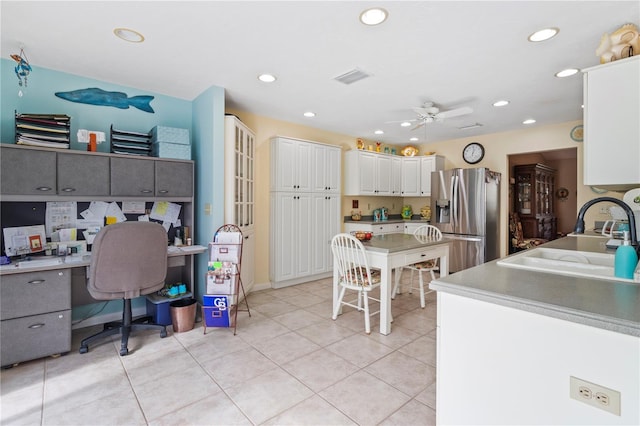 kitchen featuring stainless steel fridge with ice dispenser, white cabinetry, light tile patterned floors, ceiling fan, and sink