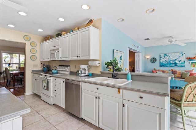 kitchen with ceiling fan, kitchen peninsula, sink, white appliances, and white cabinets