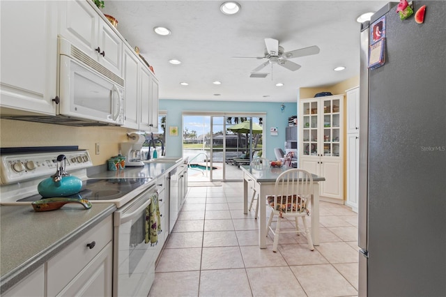 kitchen with white appliances, white cabinetry, sink, light tile patterned flooring, and ceiling fan