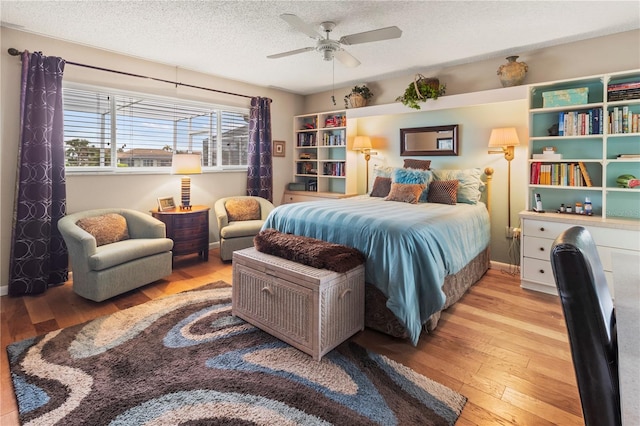 bedroom with ceiling fan, a textured ceiling, and light hardwood / wood-style flooring