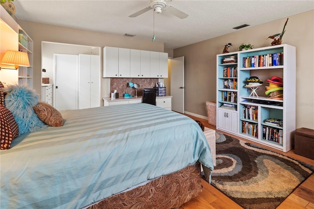 bedroom featuring ceiling fan, a textured ceiling, and hardwood / wood-style floors