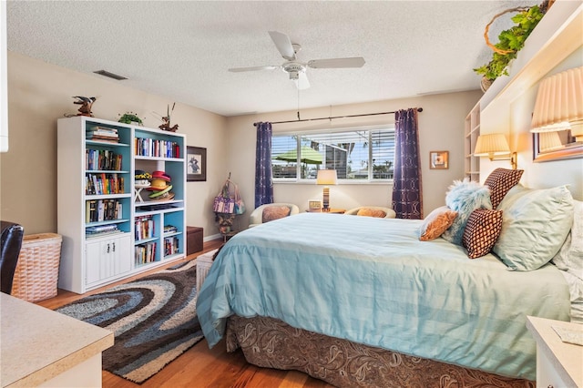 bedroom featuring ceiling fan, a textured ceiling, and hardwood / wood-style flooring