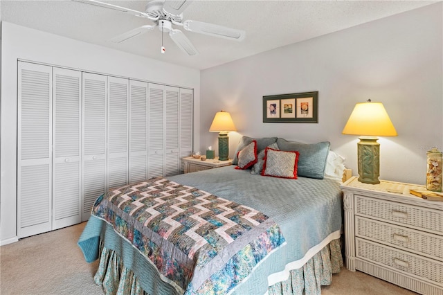 carpeted bedroom featuring ceiling fan, a closet, and a textured ceiling