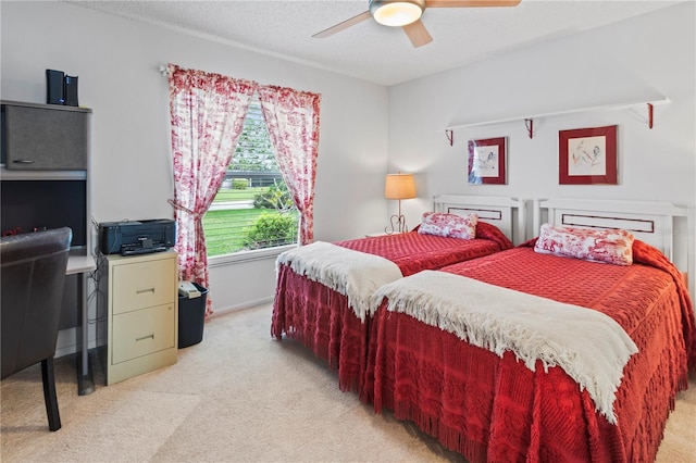 carpeted bedroom featuring ceiling fan and a textured ceiling