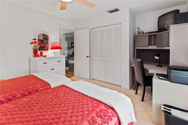 bedroom with ceiling fan, light colored carpet, and a closet