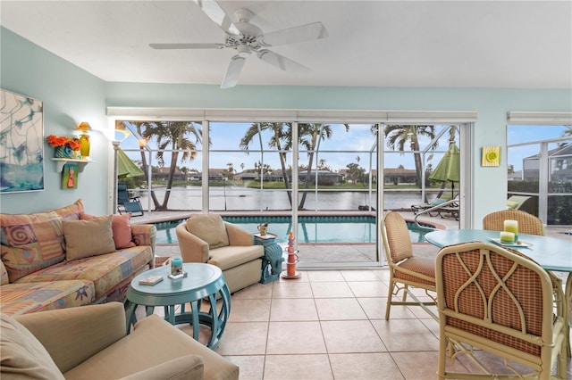 sunroom / solarium featuring a water view and ceiling fan