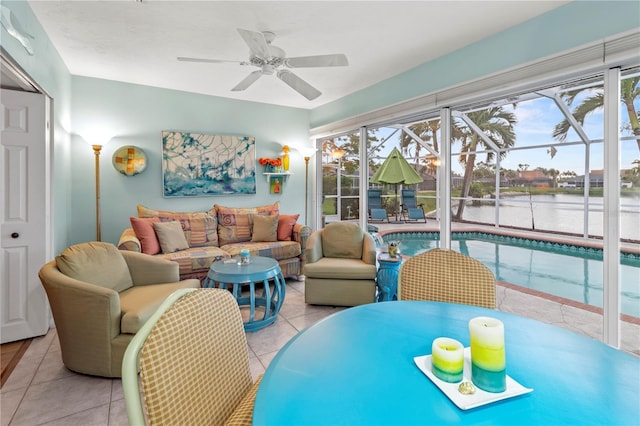 living room with ceiling fan, light tile patterned flooring, and a water view