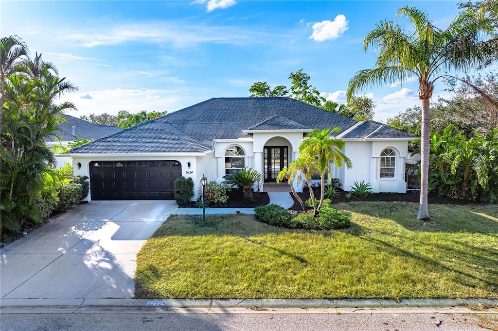 ranch-style home with a front lawn and a garage