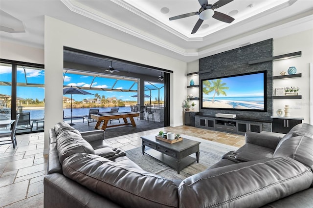 living room with crown molding, ceiling fan, and a tray ceiling