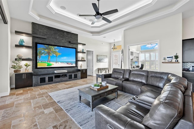 living room featuring a raised ceiling, ceiling fan, and a high ceiling