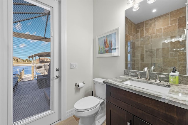 bathroom with vanity, toilet, and tiled shower