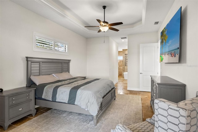 bedroom featuring ceiling fan, ensuite bathroom, and a raised ceiling