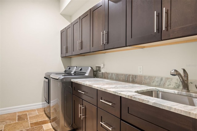 washroom with cabinets, sink, and washing machine and clothes dryer