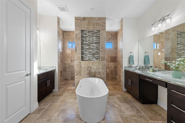 bathroom with independent shower and bath, vanity, plenty of natural light, and tile walls