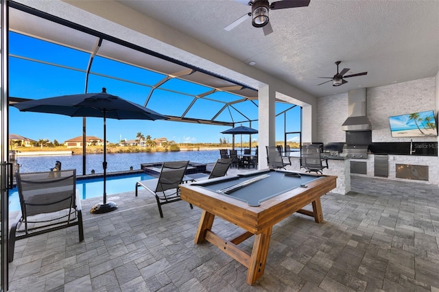 view of patio / terrace with area for grilling, glass enclosure, ceiling fan, and exterior kitchen