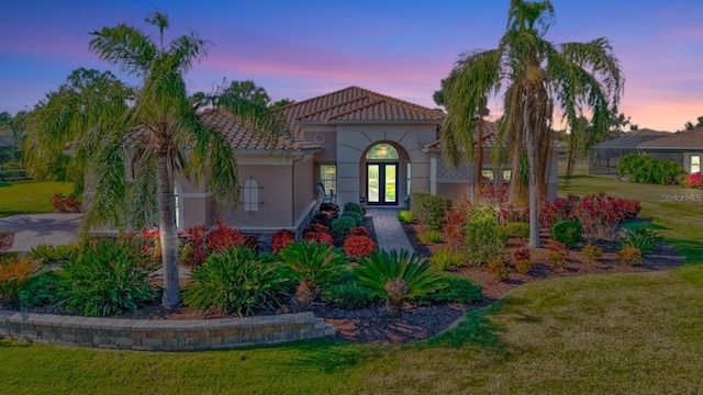 mediterranean / spanish-style house featuring glass enclosure and a yard