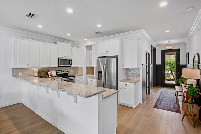 kitchen featuring kitchen peninsula, stainless steel appliances, light hardwood / wood-style floors, and white cabinetry