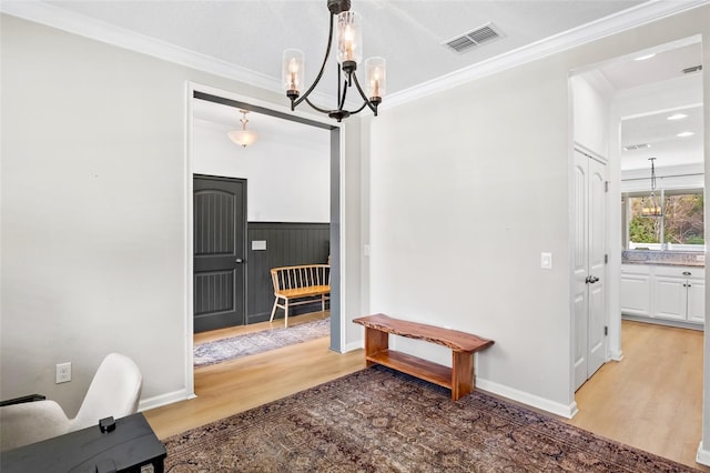 interior space with a notable chandelier, crown molding, and hardwood / wood-style floors