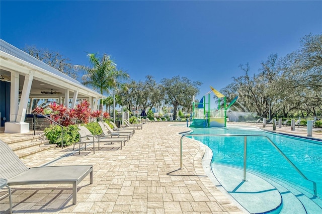 view of swimming pool featuring ceiling fan and a patio