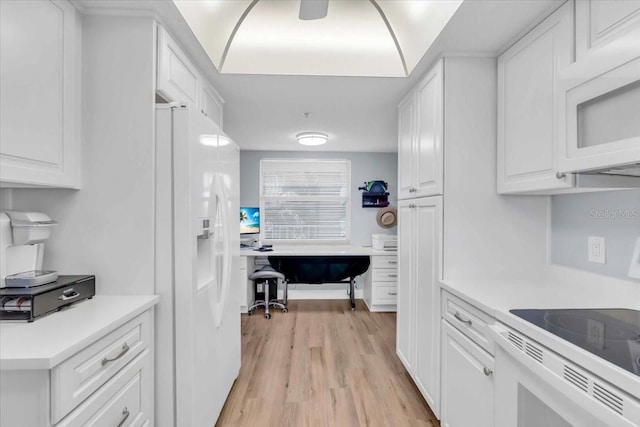 kitchen with white cabinetry, white appliances, and light hardwood / wood-style flooring