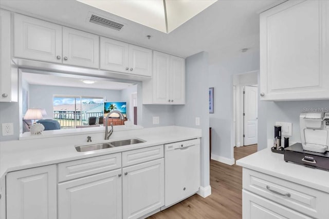 kitchen with sink, white cabinets, dishwasher, and light wood-type flooring