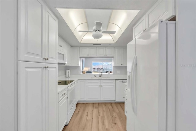 kitchen featuring white appliances, white cabinets, sink, light wood-type flooring, and ceiling fan