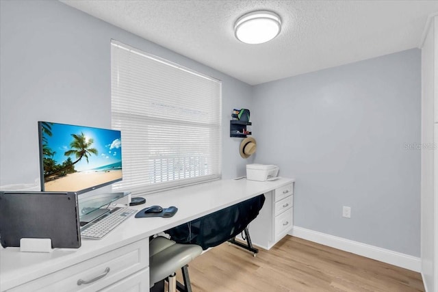 office area with a textured ceiling and light hardwood / wood-style floors