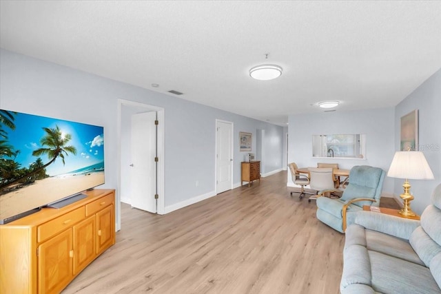 living room featuring a textured ceiling and light hardwood / wood-style flooring