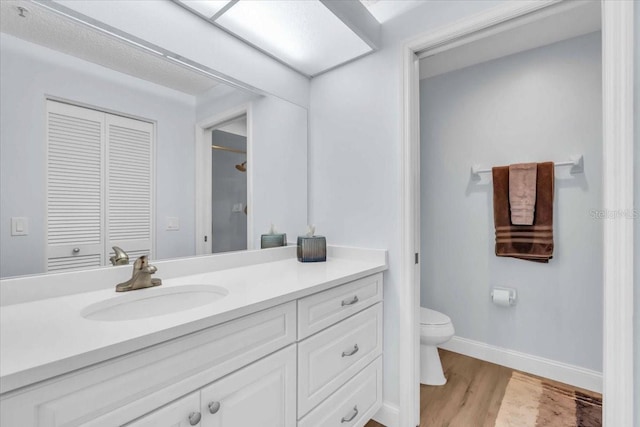 bathroom featuring toilet, hardwood / wood-style floors, and vanity