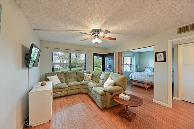 bedroom featuring ceiling fan, a textured ceiling, and light hardwood / wood-style flooring