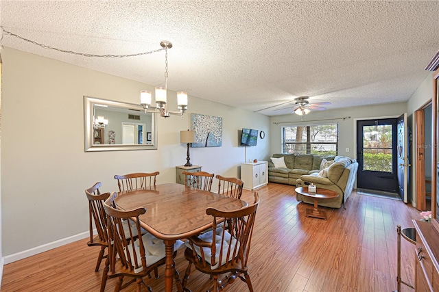 dining room featuring a textured ceiling, ceiling fan with notable chandelier, and wood-type flooring