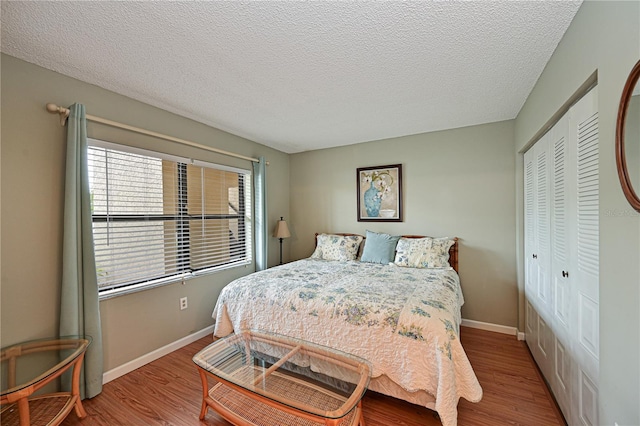 bedroom with light wood-type flooring, a closet, and a textured ceiling