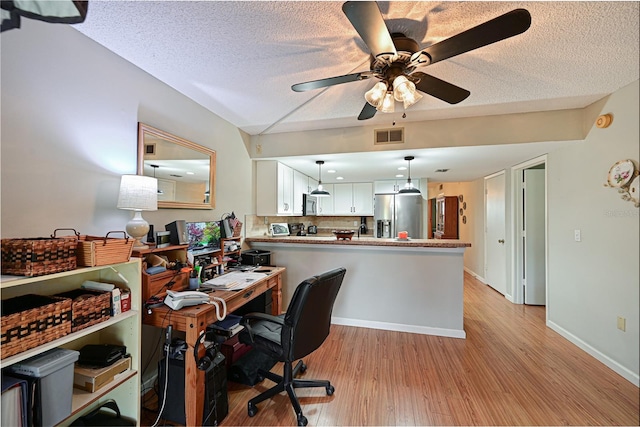 office with ceiling fan, a textured ceiling, and light wood-type flooring