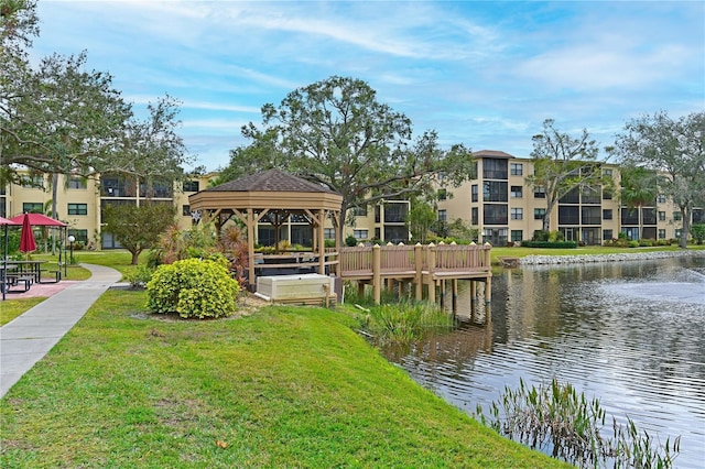 exterior space featuring a water view, a gazebo, and a lawn