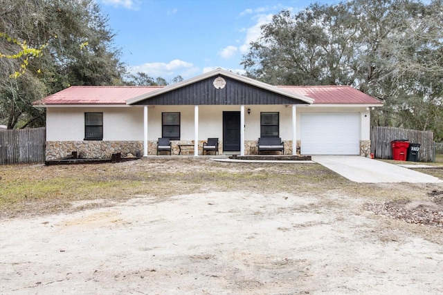 single story home featuring a garage and a porch