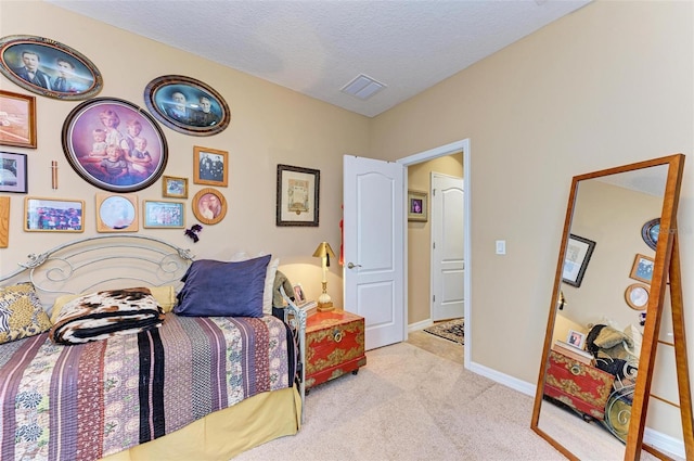 bedroom with light carpet and a textured ceiling