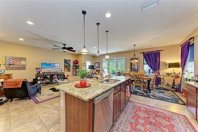 kitchen with sink, hanging light fixtures, stainless steel dishwasher, light stone countertops, and a center island with sink