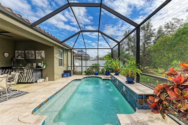 view of pool featuring pool water feature, an outdoor kitchen, a lanai, and a patio area