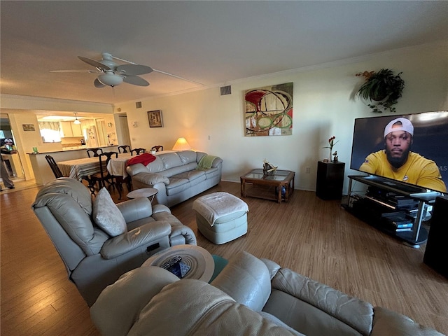 living room featuring ceiling fan, ornamental molding, and hardwood / wood-style floors