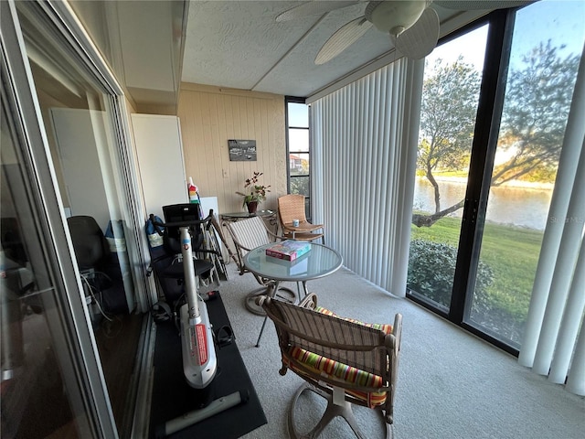 sunroom / solarium with a water view and ceiling fan