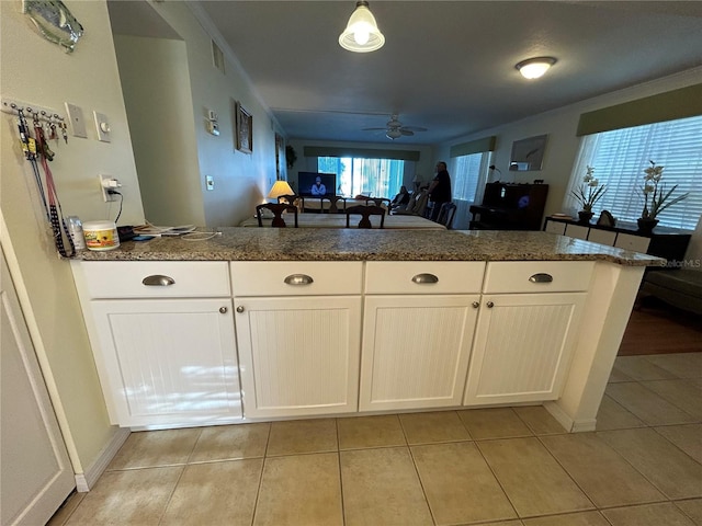 kitchen with light tile patterned floors, white cabinetry, pendant lighting, and ceiling fan