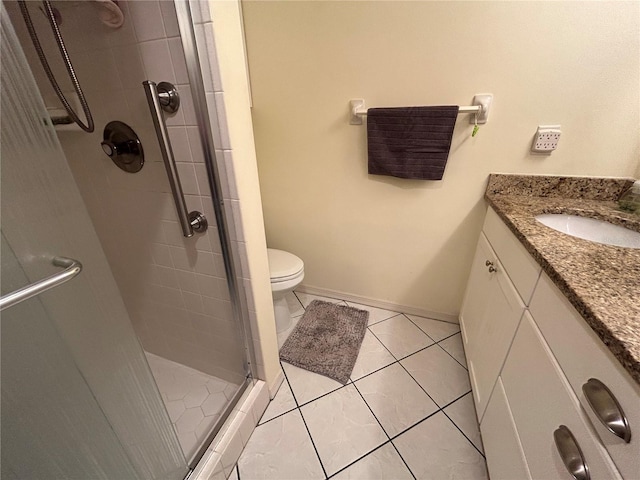 bathroom featuring an enclosed shower, vanity, tile patterned flooring, and toilet