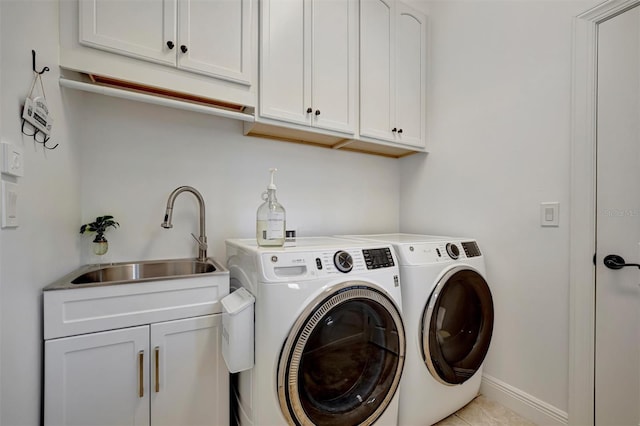 laundry area with cabinets, light tile patterned floors, washing machine and clothes dryer, and sink