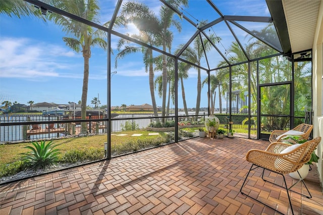 sunroom featuring a water view